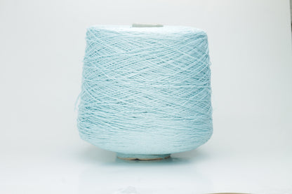 Close-up of fine, natural Linuzzo-colored 100% linen yarn, showing its smooth, slightly matte texture and subtle ply twist, coiled loosely.