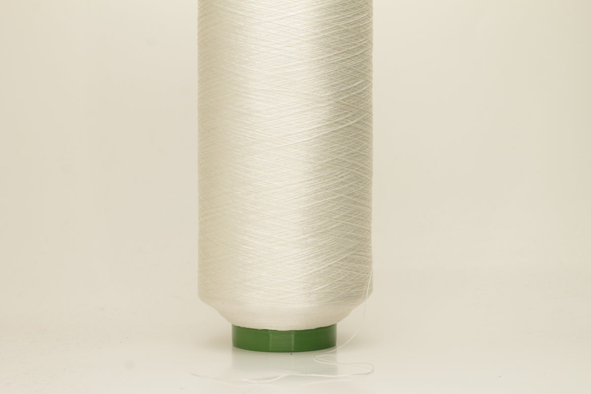 Close-up of pristine white, finely plied 100% silk yarn, twisted smoothly to reveal a high, lustrous sheen and uniform structure.