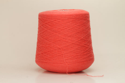 Luxurious two-ply cashmere yarn in vibrant coral (Corallo), showcasing a soft, subtle twist, smooth texture, and elegant natural sheen.