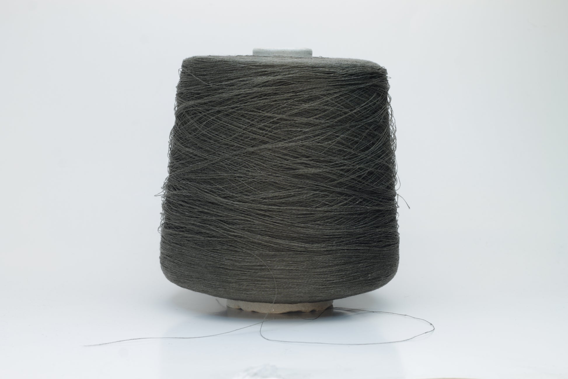 Skein of finely spun yarn, a muted artichoke green. Its smooth, even twist reveals the crisp texture of linen with a subtle, natural sheen. Low fluff, clean look.