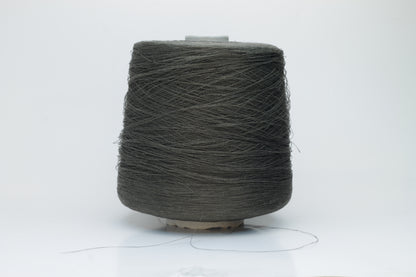 Skein of finely spun yarn, a muted artichoke green. Its smooth, even twist reveals the crisp texture of linen with a subtle, natural sheen. Low fluff, clean look.