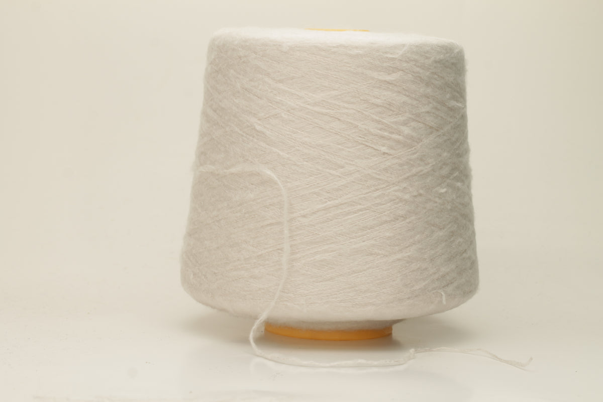 Luxurious, pristine white single-ply silk yarn with a smooth, uniform texture and a delicate sheen, softly coiled.