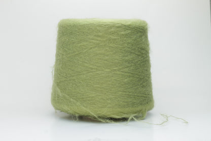 Close-up shot of vibrant green SuperKidMohair yarn showcasing a tight ply twist and rich fiber structure, revealing its inherent fluffiness and subtle sheen.