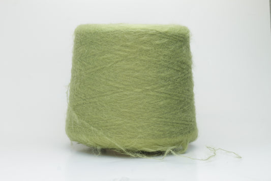 Close-up shot of vibrant green SuperKidMohair yarn showcasing a tight ply twist and rich fiber structure, revealing its inherent fluffiness and subtle sheen.