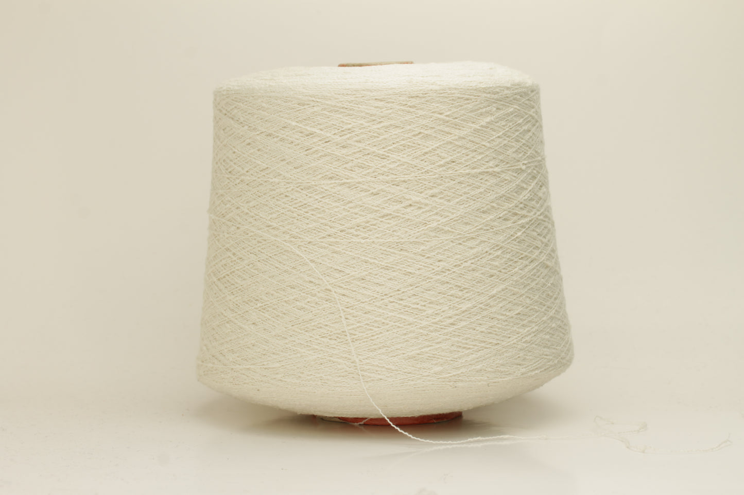 Close-up of a pure white, textured Nodino yarn, showing subtle, irregular nubs and a soft, matte sheen; twisted ply visible.