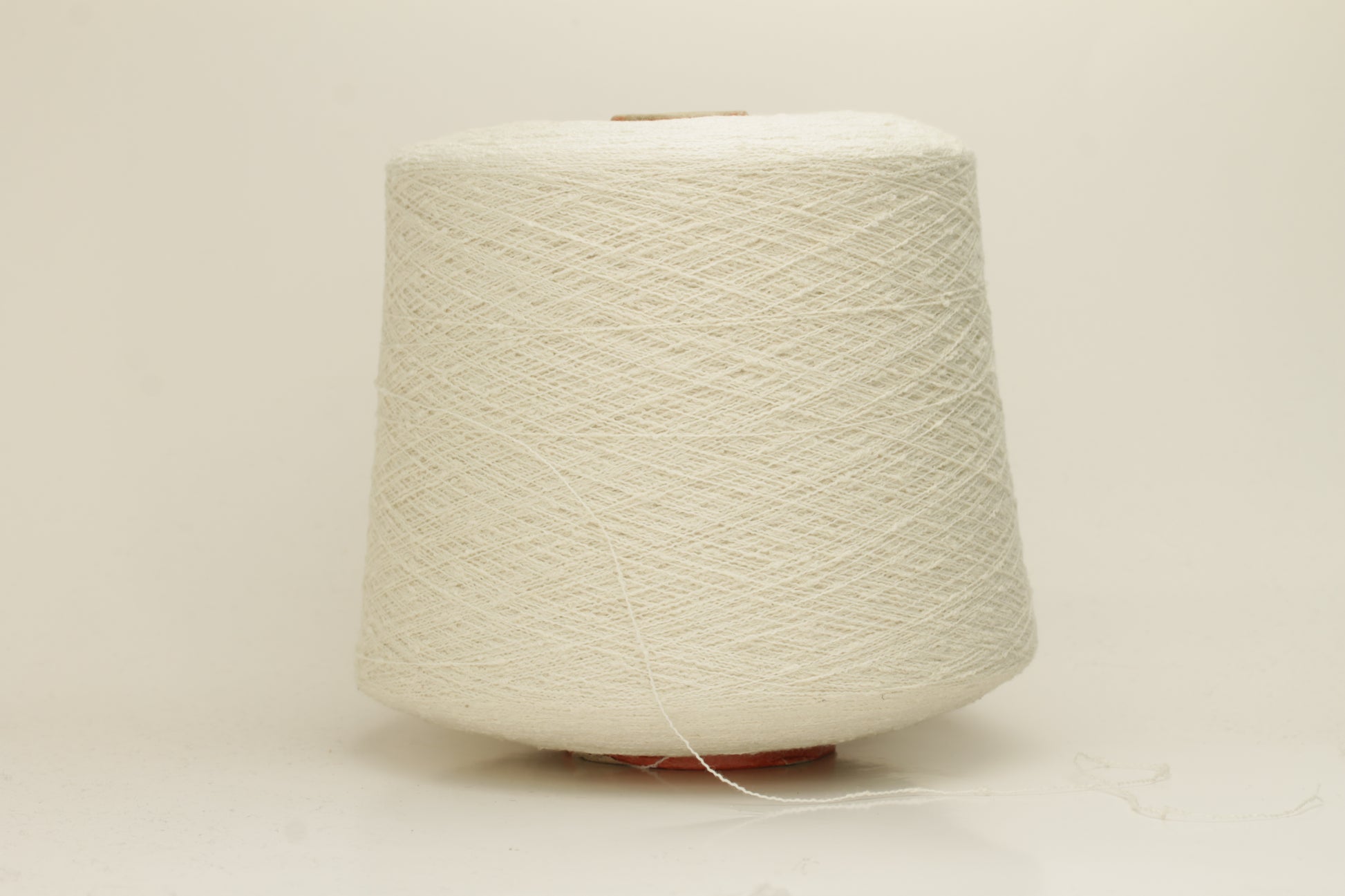 Close-up of a pure white, textured Nodino yarn, showing subtle, irregular nubs and a soft, matte sheen; twisted ply visible.