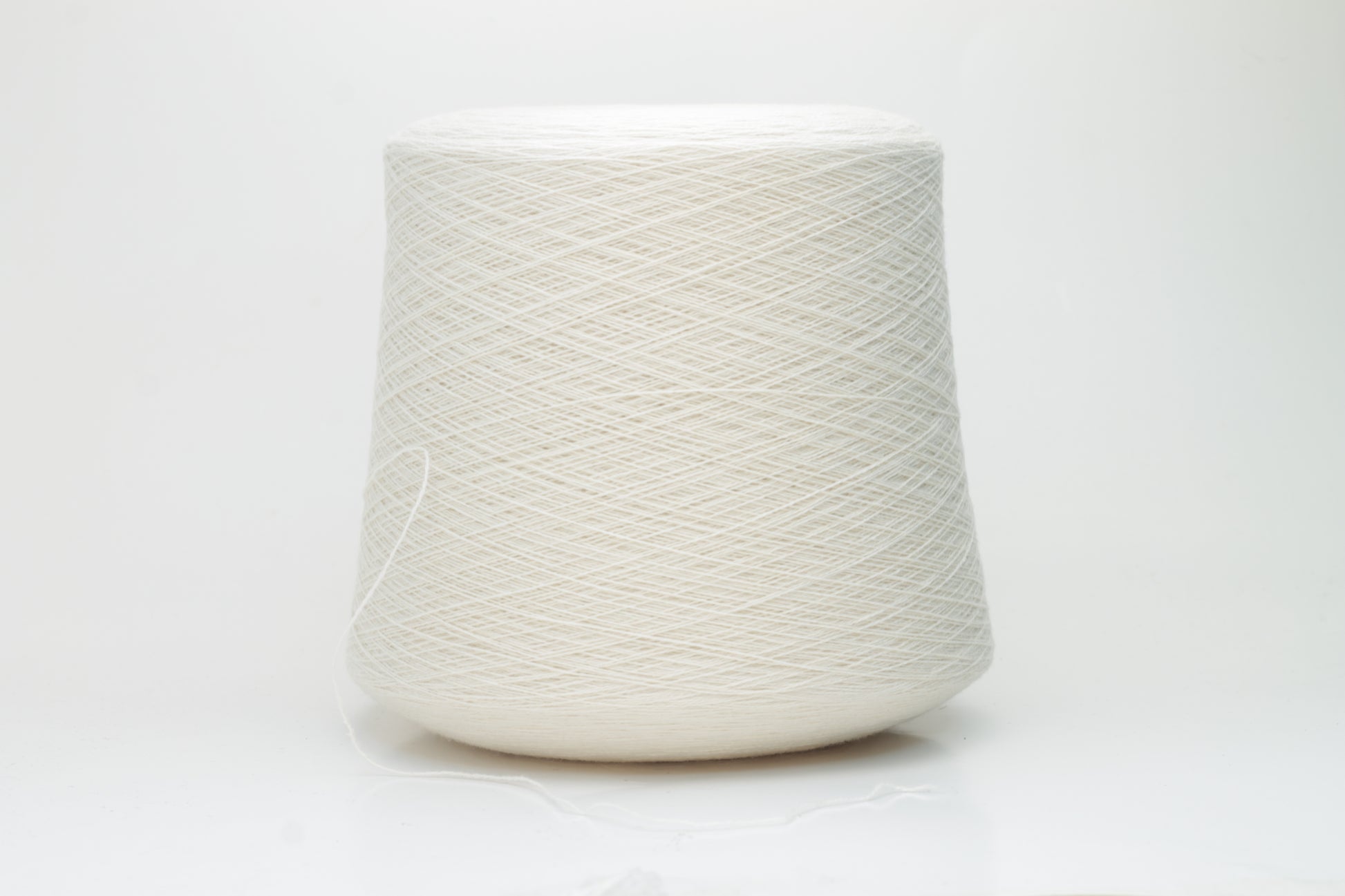 Close-up of a finely spun, 2-ply cashmere yarn skein in a delicate, warm champagne beige. Features a soft, subtle napped texture and elegant sheen.