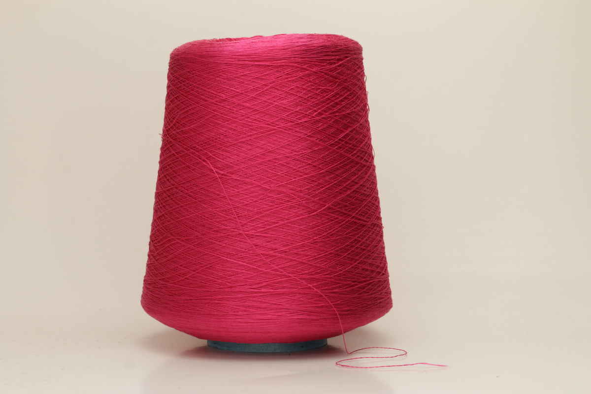 Close-up of vibrant hot pink 100% pure silk yarn, showcasing its fine, smooth single ply and high, natural luster reflecting light beautifully.