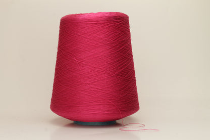 Close-up of vibrant hot pink 100% pure silk yarn, showcasing its fine, smooth single ply and high, natural luster reflecting light beautifully.