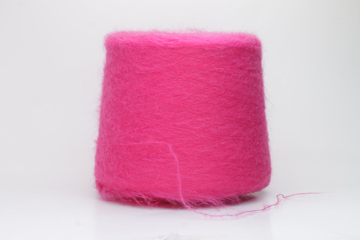 Close-up view of SuperKidMohair yarn in Fuxia, showcasing its fluffy texture and slightly twisted ply structure with subtle sheen.