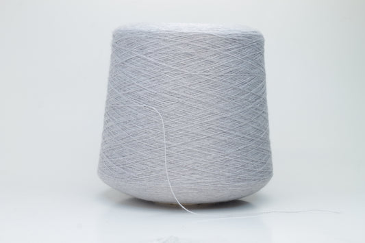 Close-up of a luxurious light blue merino wool yarn skein, showcasing its fine ply twist and subtle sheen, emphasizing the soft fluffiness and vibrant color depth.