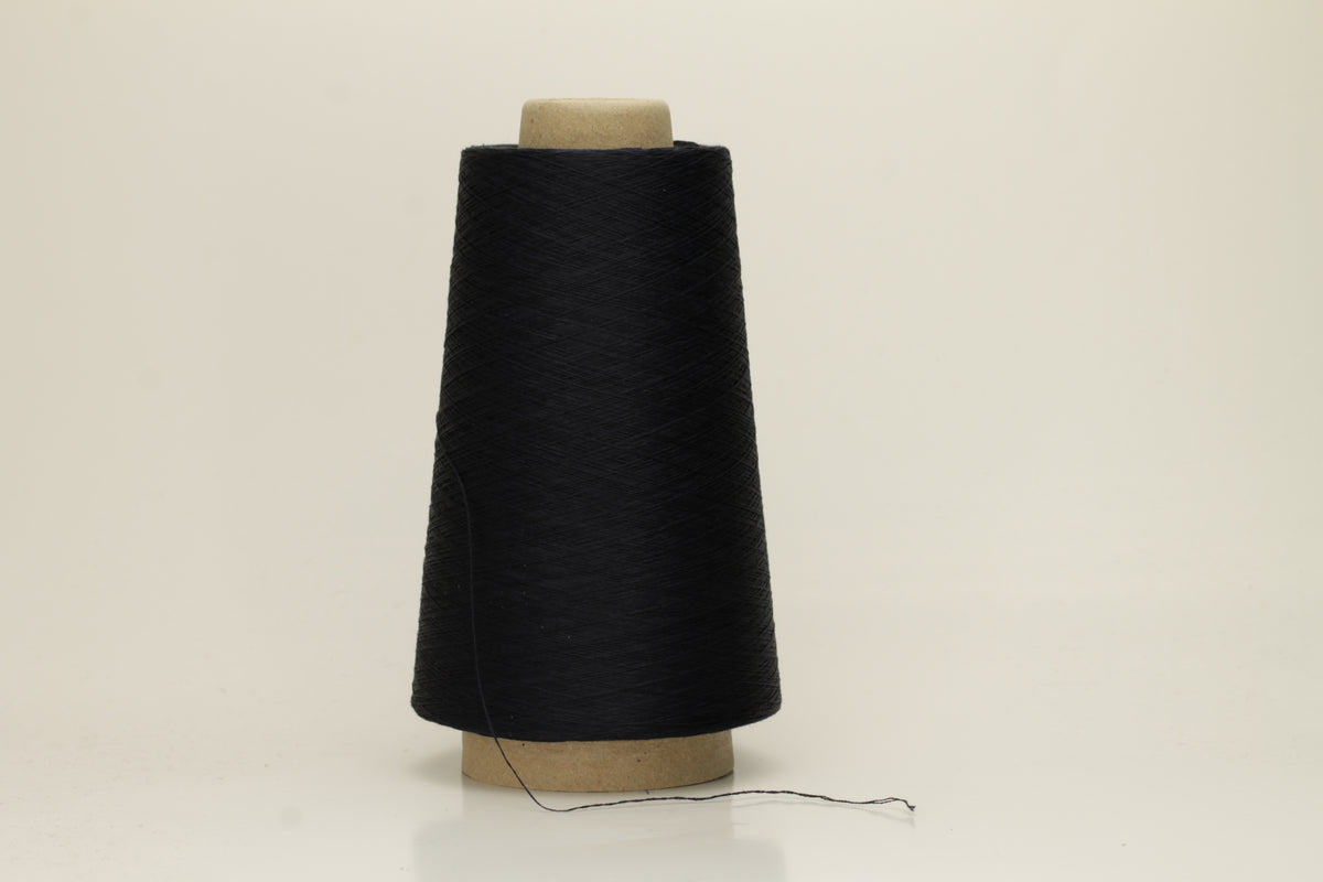A skein of fine, single-ply 100% silk yarn, lustrous with a deep, rich dark midnight blue hue, reflecting light softly.