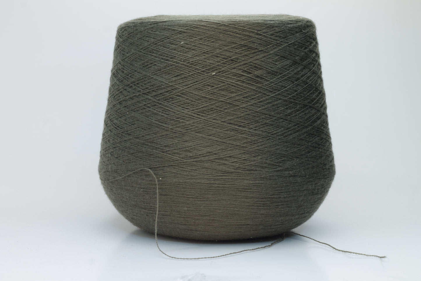 Close-up shot of a vibrant green Merino 100% Cashwool yarn skein. The yarn features a tight, dense ply twist and a subtle sheen, with visible individual strands creating a rich, textured effect.