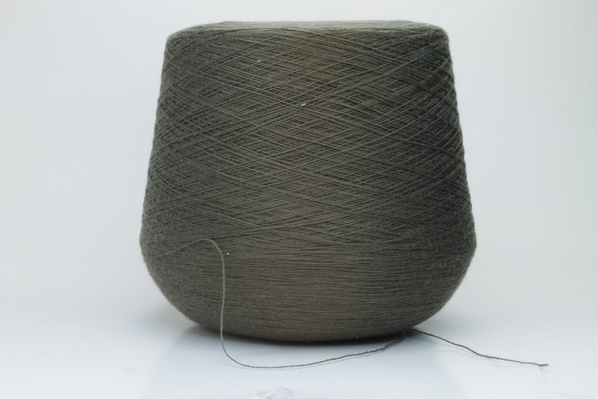Close-up shot of a vibrant green Merino 100% Cashwool yarn skein. The yarn features a tight, dense ply twist and a subtle sheen, with visible individual strands creating a rich, textured effect.