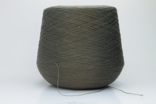Close-up shot of a vibrant green Merino 100% Cashwool yarn skein. The yarn features a tight, dense ply twist and a subtle sheen, with visible individual strands creating a rich, textured effect.