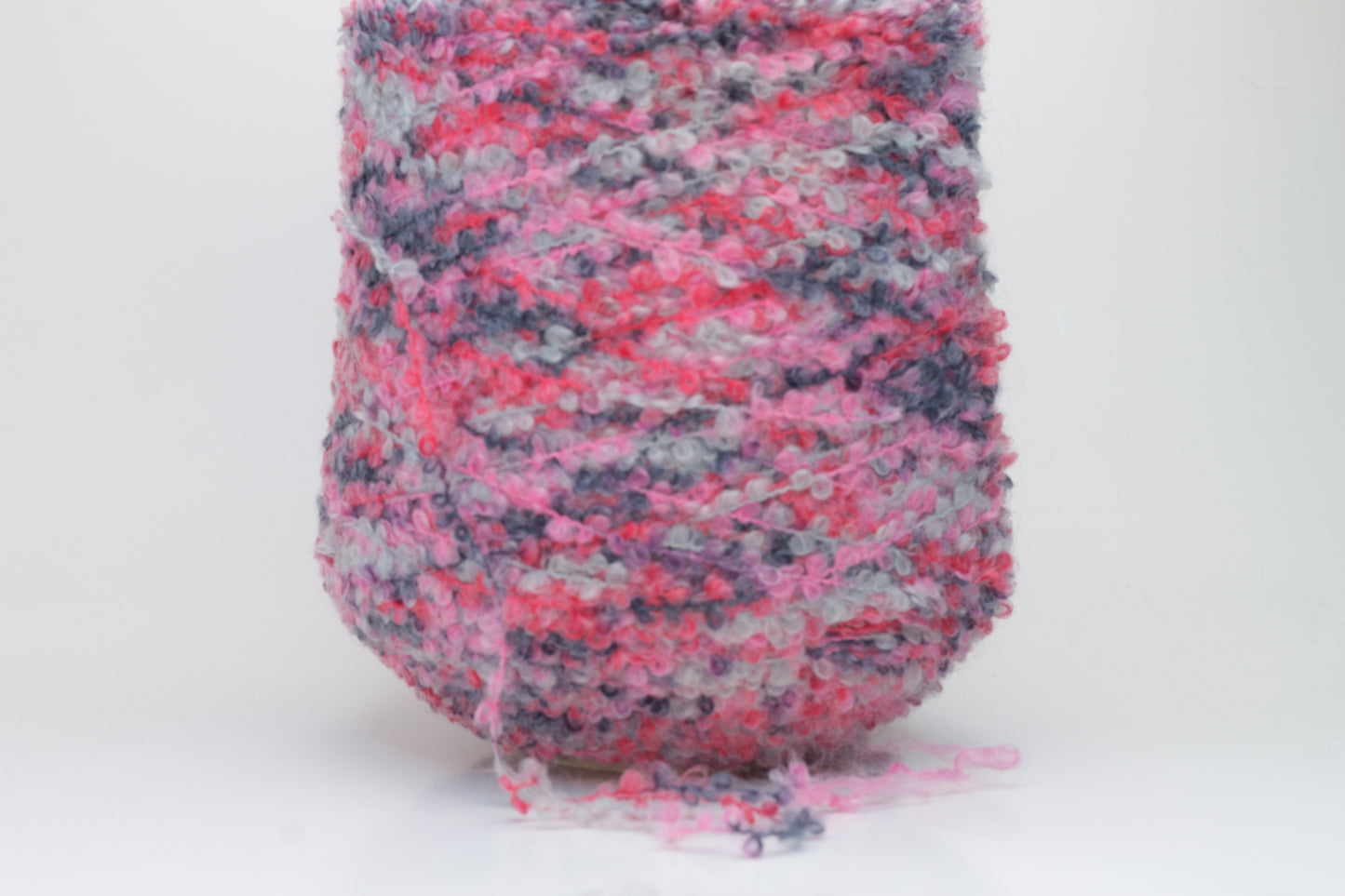 Close-up shot of multicolored SuperKidMohair yarn, showcasing its fluffy texture, slight sheen, and tight ply twist – a rich blend ready for knitting or weaving.