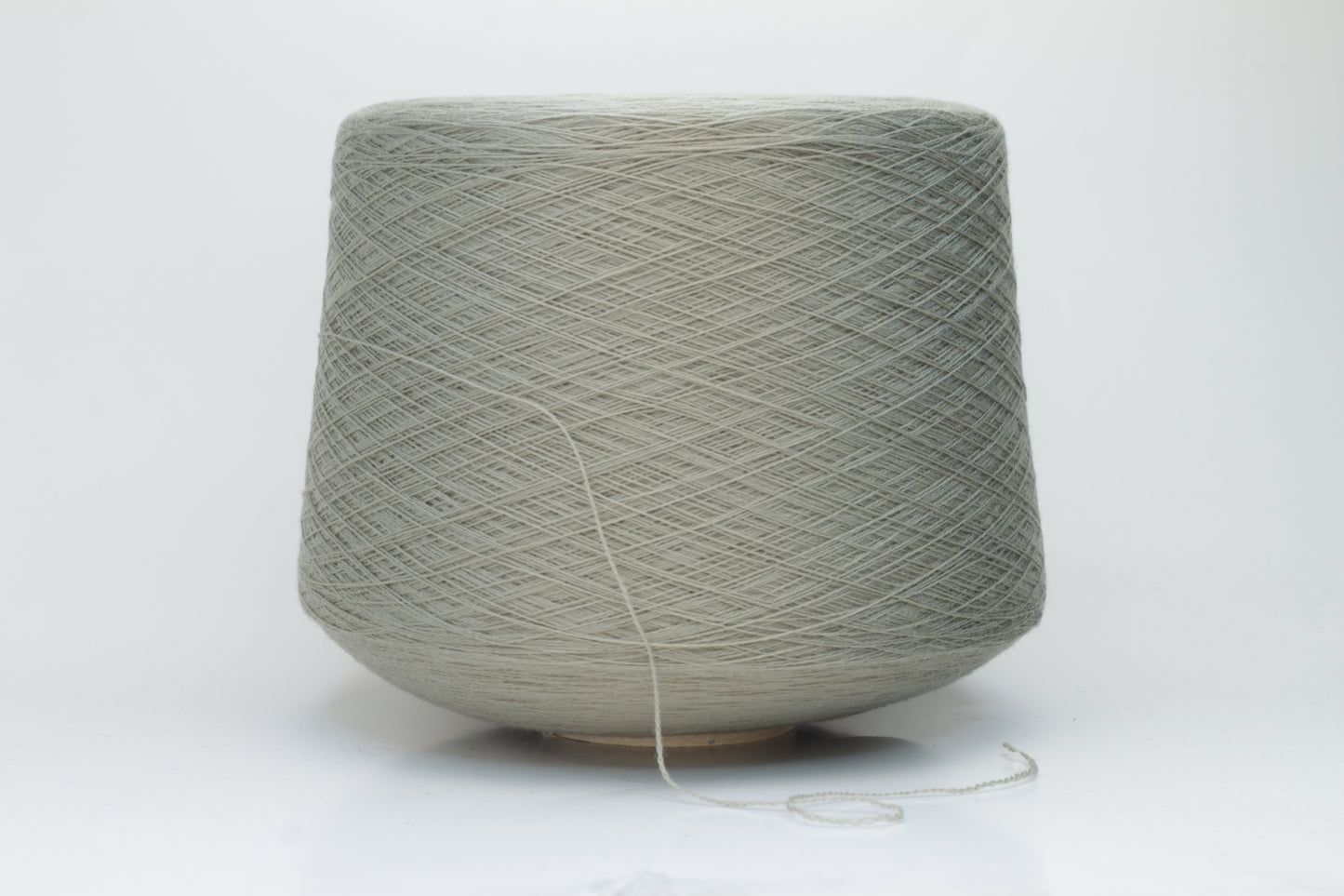 Close-up shot of the grey merino yarn, showcasing its fine 2/30 ply twist and subtle sheen, with a fluffy texture revealed through careful lighting.