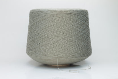 Close-up shot of the grey merino yarn, showcasing its fine 2/30 ply twist and subtle sheen, with a fluffy texture revealed through careful lighting.