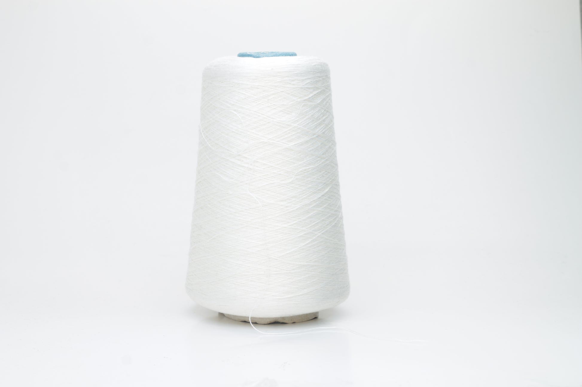 Fine, pure white silk yarn, tightly twisted with a subtle, radiant sheen. Smooth texture, uniform ply, elegant thread structure for delicate projects.