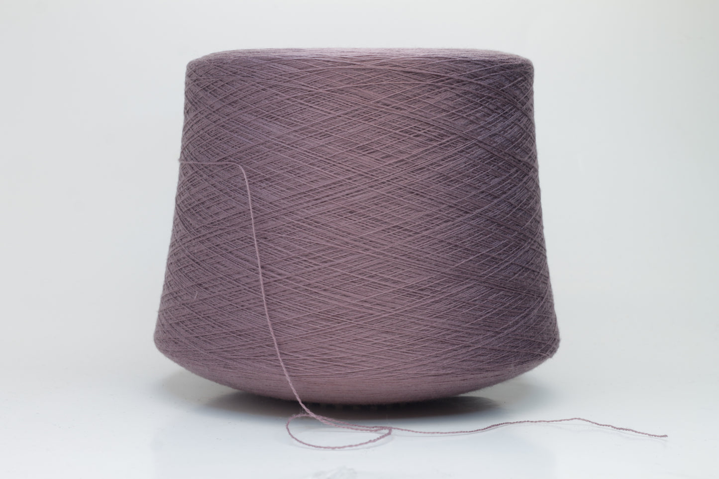 Close-up shot of Zegna Baruffa Merino 100% Cashwool yarn in color 438 Ninfea, showcasing the fine ply twist and rich, deep hue of the fibers.