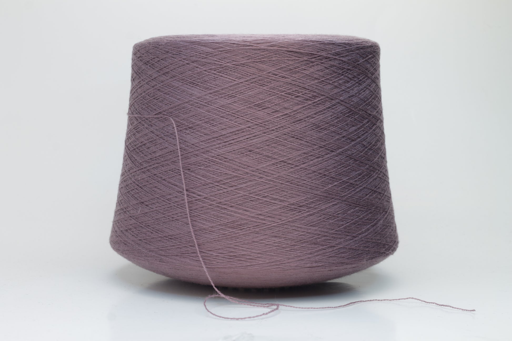 Close-up shot of Zegna Baruffa Merino 100% Cashwool yarn in color 438 Ninfea, showcasing the fine ply twist and rich, deep hue of the fibers.