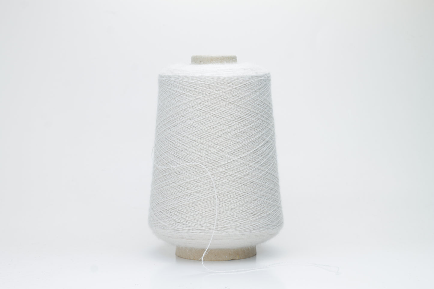 Close-up of lustrous beige 2-ply alpaca merino yarn, subtly twisted with a fine, even structure and soft, low halo.