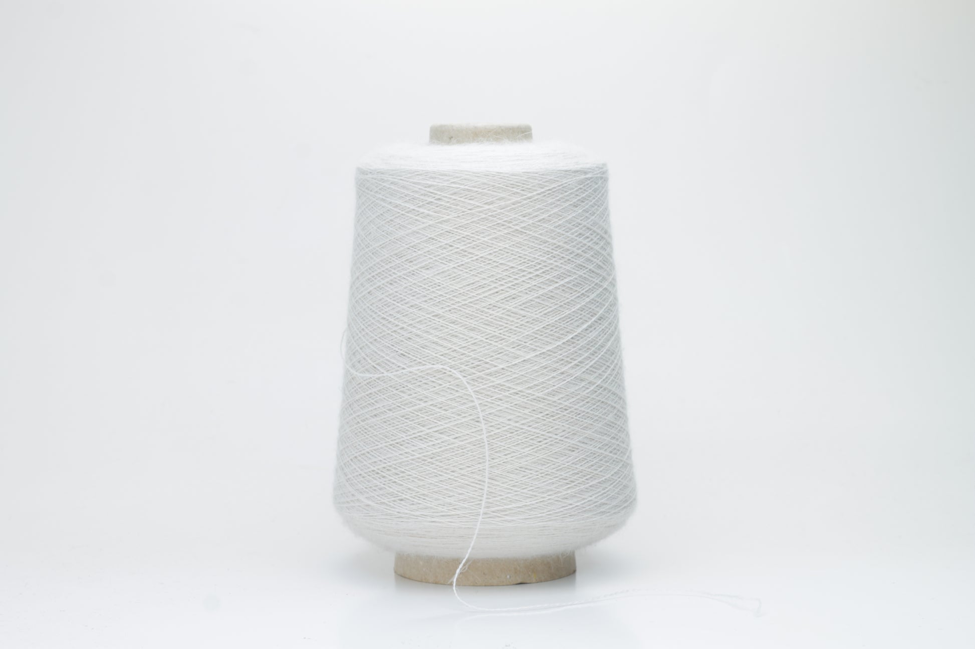 Close-up of lustrous beige 2-ply alpaca merino yarn, subtly twisted with a fine, even structure and soft, low halo.