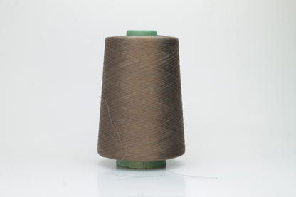 Finely spun, single-ply silk yarn in a deep, rich cacao brown, exhibiting a smooth, tight twist and brilliant, natural sheen.