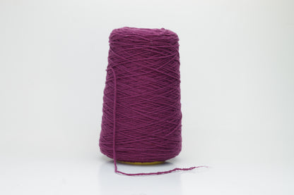 Close-up of soft, lustrous pure cashmere yarn, gently twisted, revealing a rich, deep anemone purple with a subtle, velvety halo.