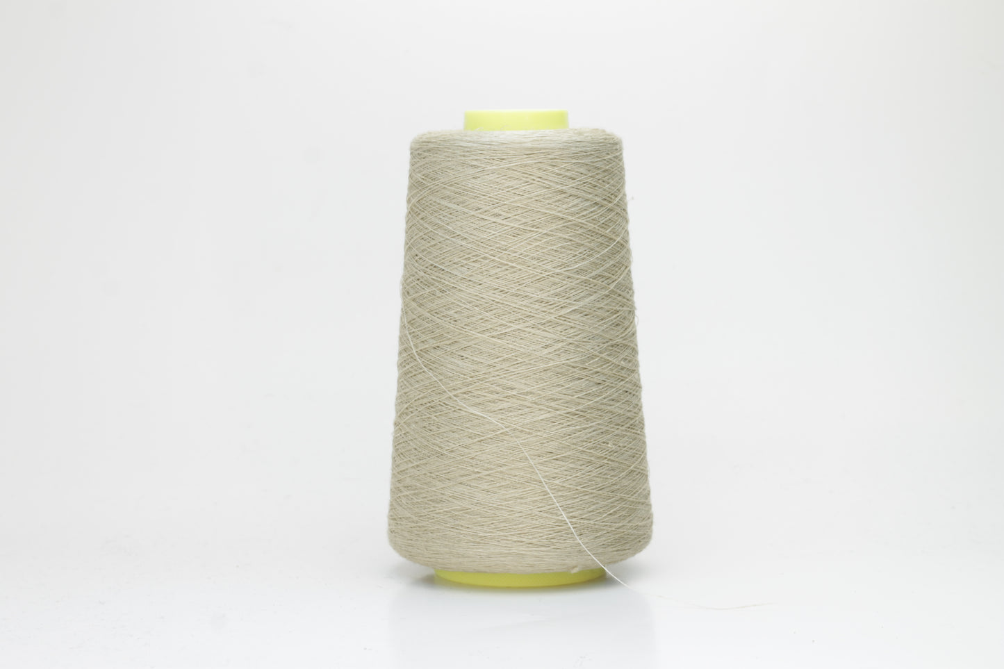 Fine, single-ply linen yarn in a rich Pale Oatmeal. Reveals a crisp texture and subtle natural sheen, typical of pure linen fiber.