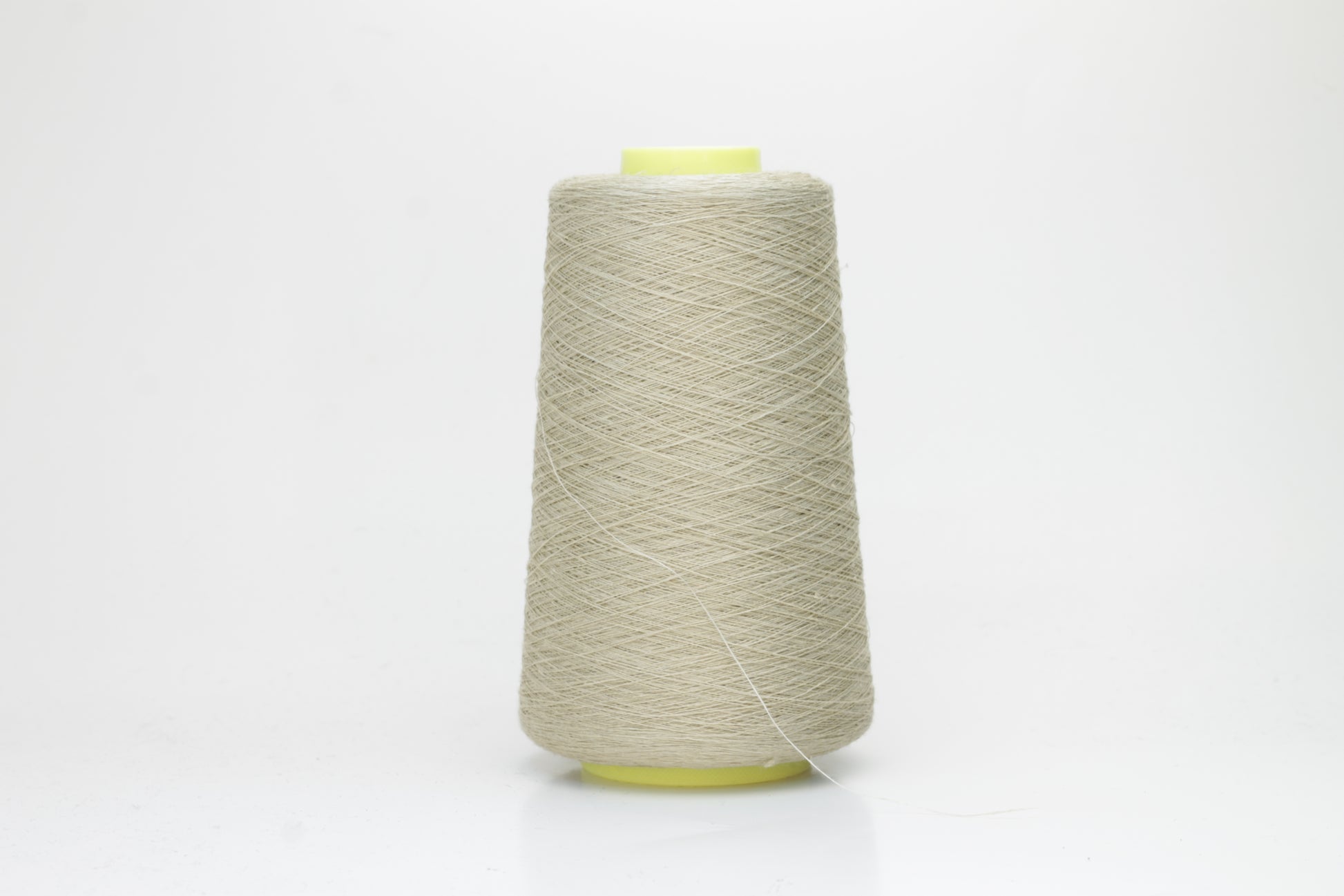 Fine, single-ply linen yarn in a rich Pale Oatmeal. Reveals a crisp texture and subtle natural sheen, typical of pure linen fiber.