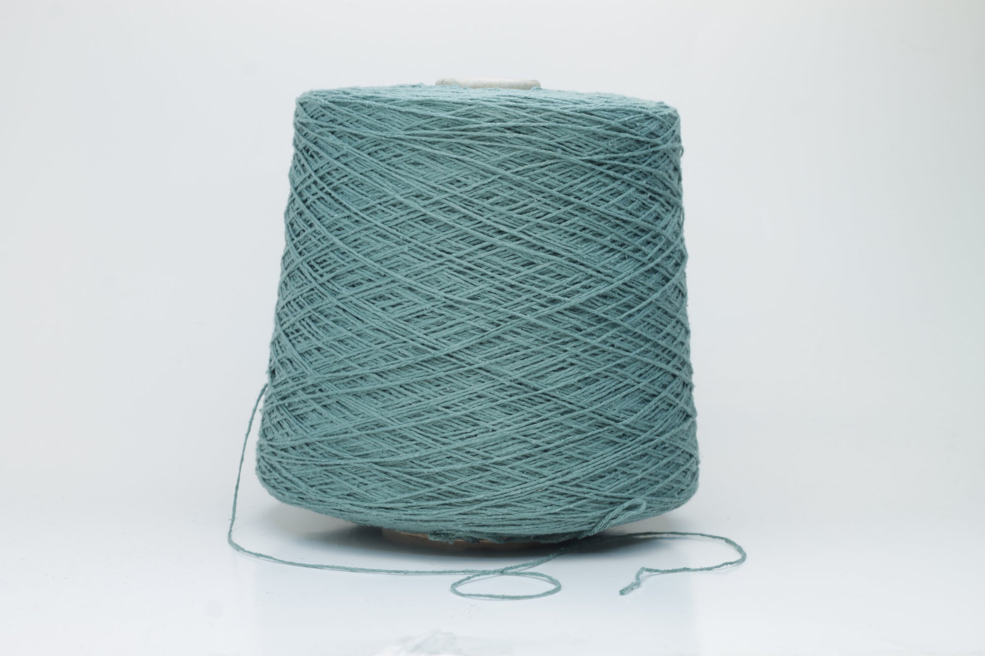 Close-up shot of shimmering silk bourette yarn in a rich verdone color. The multi-plied strands show subtle twist and depth, with a delicate sheen and fluffy texture.