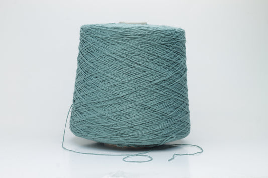 Close-up shot of shimmering silk bourette yarn in a rich verdone color. The multi-plied strands show subtle twist and depth, with a delicate sheen and fluffy texture.