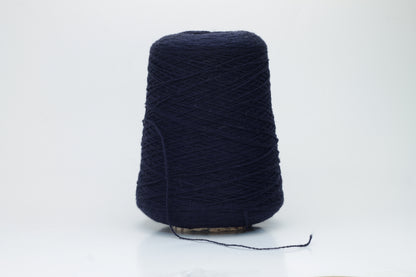A tightly spun two-ply yarn, rich navy blue, made from exceptionally soft, fine cashmere fibers with a slight halo, presented as a graceful hank.