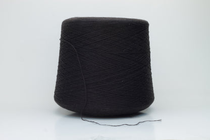 Close-up of a two-ply dark brown cashmere yarn, softly twisted with a subtle sheen, displaying its deep rich hue and delicate fuzziness, ready for luxury crafting.