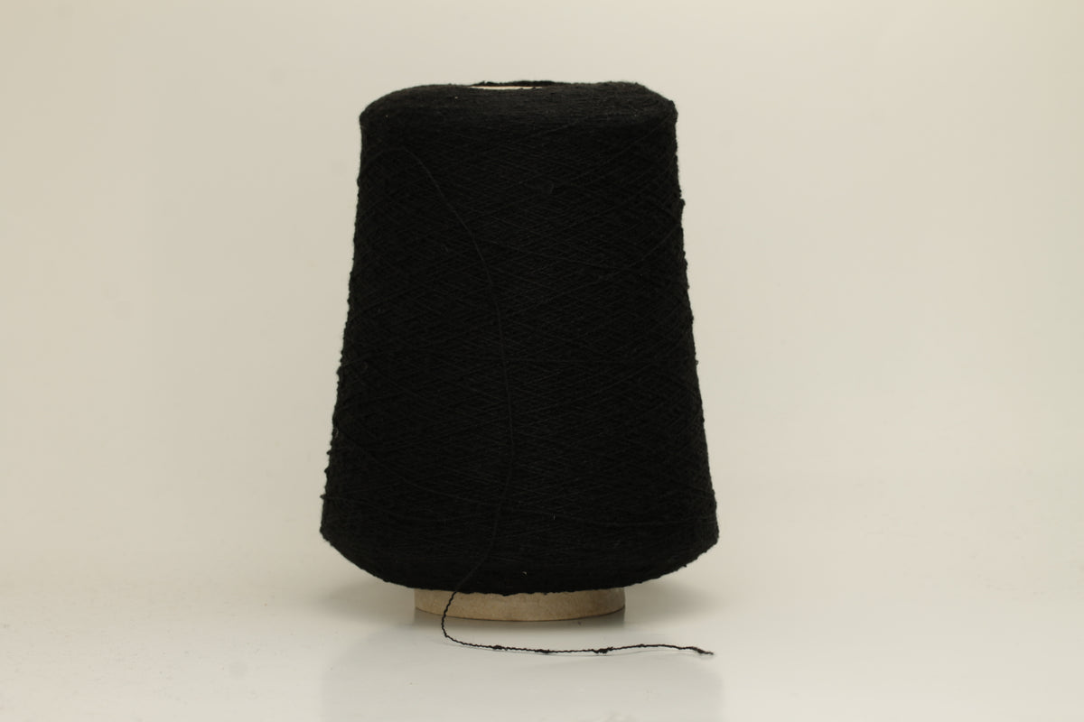 Close-up of a Black, textured Nodino yarn, showing subtle, irregular nubs and a soft, matte sheen; twisted ply visible.