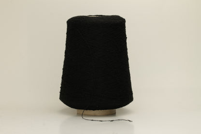Close-up of a Black, textured Nodino yarn, showing subtle, irregular nubs and a soft, matte sheen; twisted ply visible.