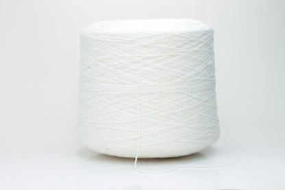 Close-up of pristine white, finely plied 100% cashmere yarn, showcasing its soft halo and subtle sheen on a neutral background.
