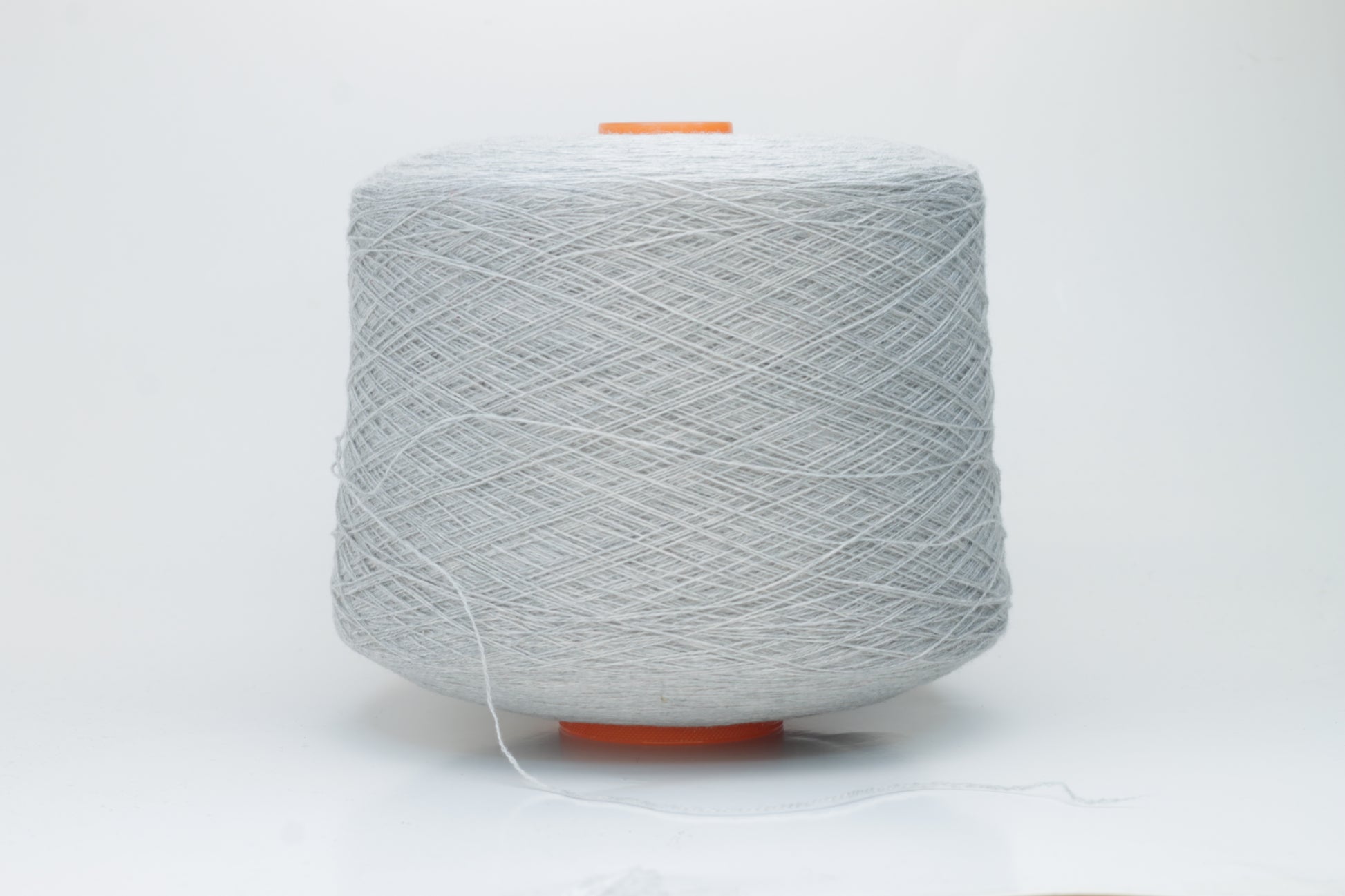 Close-up of a skein of luxurious, soft gray 100% cashmere yarn, featuring a gentle halo and a subtle, refined sheen. The two-ply structure is visible, showing even twist and consistent depth of the elegant cool gray color.
