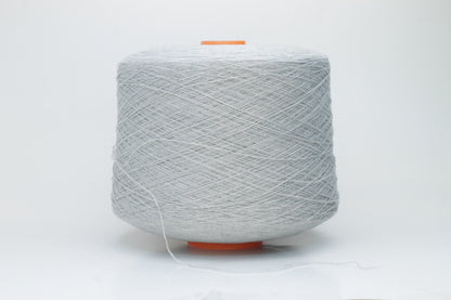 Close-up of a skein of luxurious, soft gray 100% cashmere yarn, featuring a gentle halo and a subtle, refined sheen. The two-ply structure is visible, showing even twist and consistent depth of the elegant cool gray color.