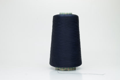 Close-up of a neatly wound spool of fine navy silk yarn, exhibiting a smooth, tightly twisted two-ply structure and a subtle, elegant sheen under direct light. The deep blue color appears rich and consistent.