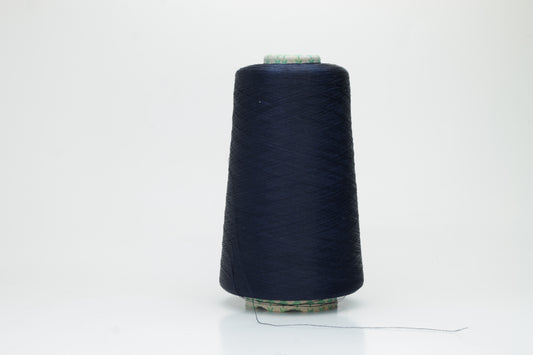 Close-up of a neatly wound spool of fine navy silk yarn, exhibiting a smooth, tightly twisted two-ply structure and a subtle, elegant sheen under direct light. The deep blue color appears rich and consistent.