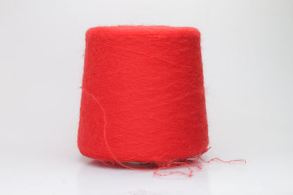 Close-up view of vibrant red SuperKidMohair yarn featuring a dense, fluffy pile with subtle sheen. The ply twist is evident in the slightly twisted structure, creating a soft and luxurious tactile experience.