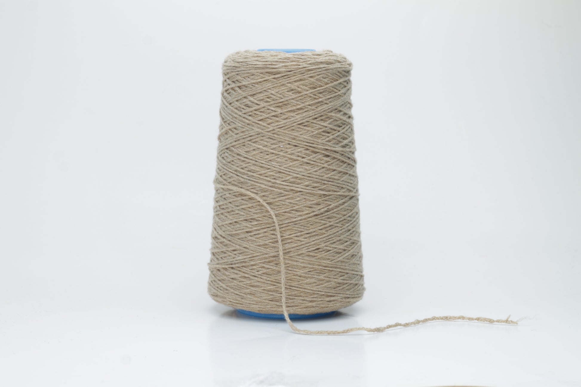 A skein of finely spun single-ply cashmere yarn in a delicate, muted grey-pink 'Polvere' shade, showcasing its inherent soft fluffiness and subtle, natural sheen.
