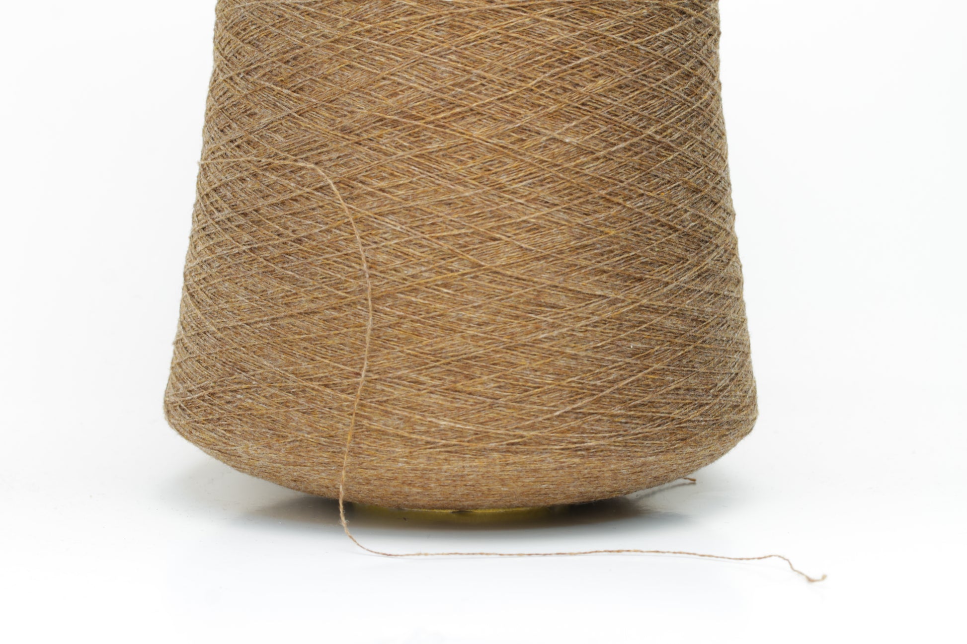 Close-up of a perfectly twisted two-ply cashmere yarn in a rich, warm brown shade, exhibiting a subtle natural sheen and delicate fluffiness.