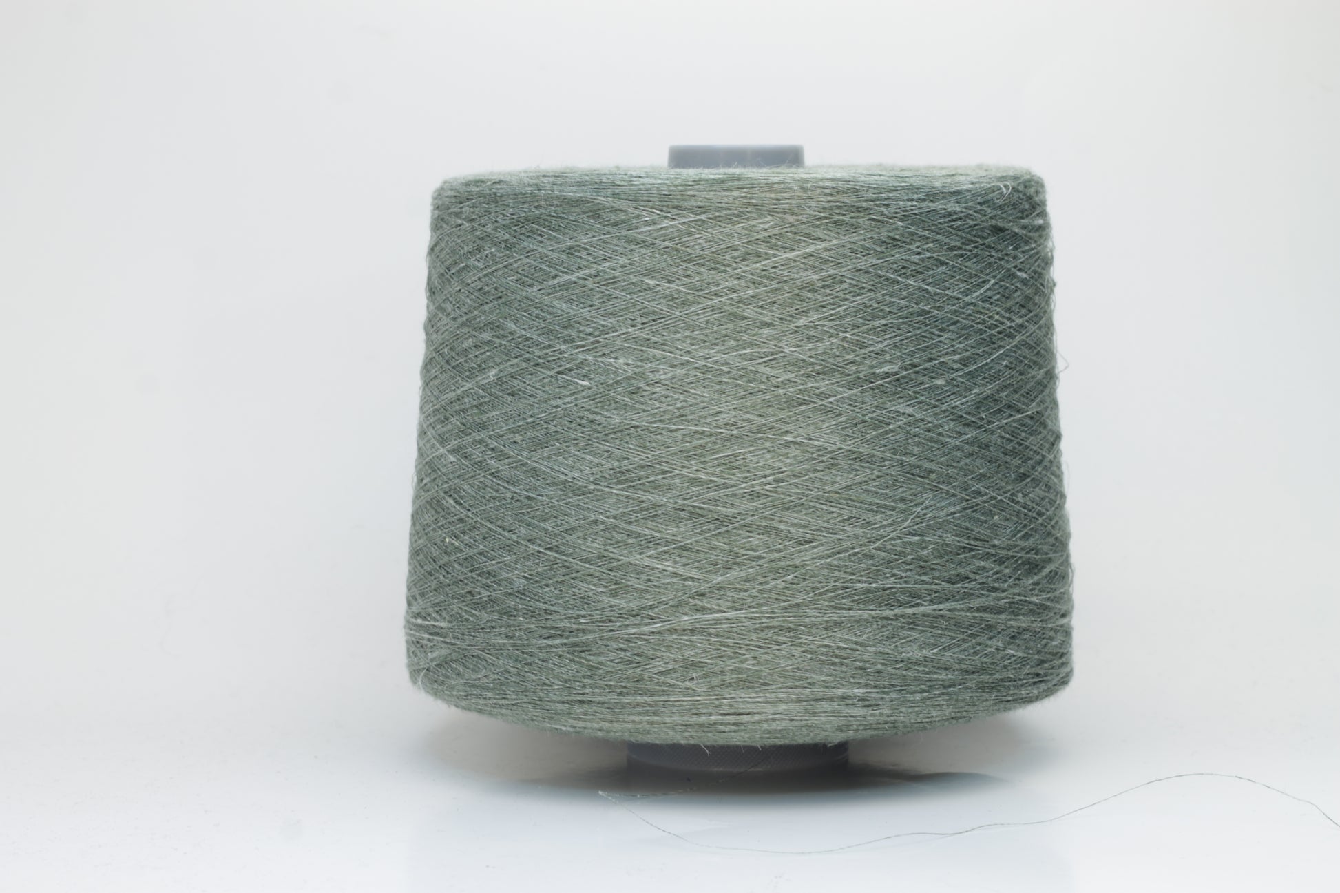 Fine, single-ply linen yarn in a rich Sage Green. Reveals a crisp texture and subtle natural sheen, typical of pure linen fiber.