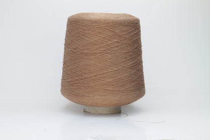 A finely spun, single-ply yarn in an earthy light brown hue, showcasing a delicate, rustic texture and a subtle, natural matte sheen.