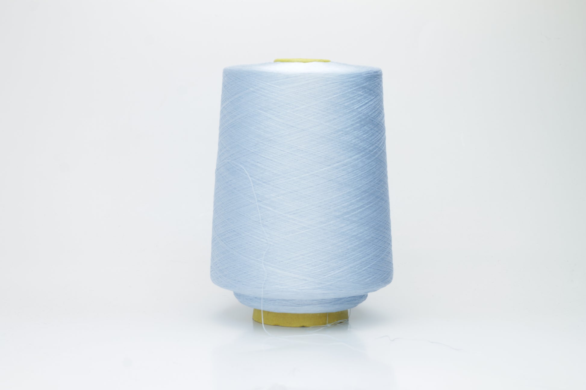 Close-up of radiant Azzurro blue silk yarn, featuring a finely spun, lustrous organzino thread with a pronounced, smooth sheen.