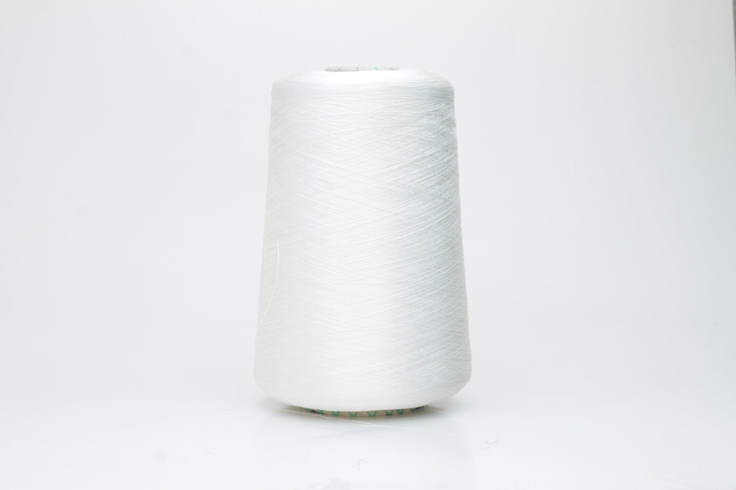 Close-up of brilliant white 100% silk yarn, single-ply strand with a smooth, highly lustrous surface, softly draped. Shimmering.