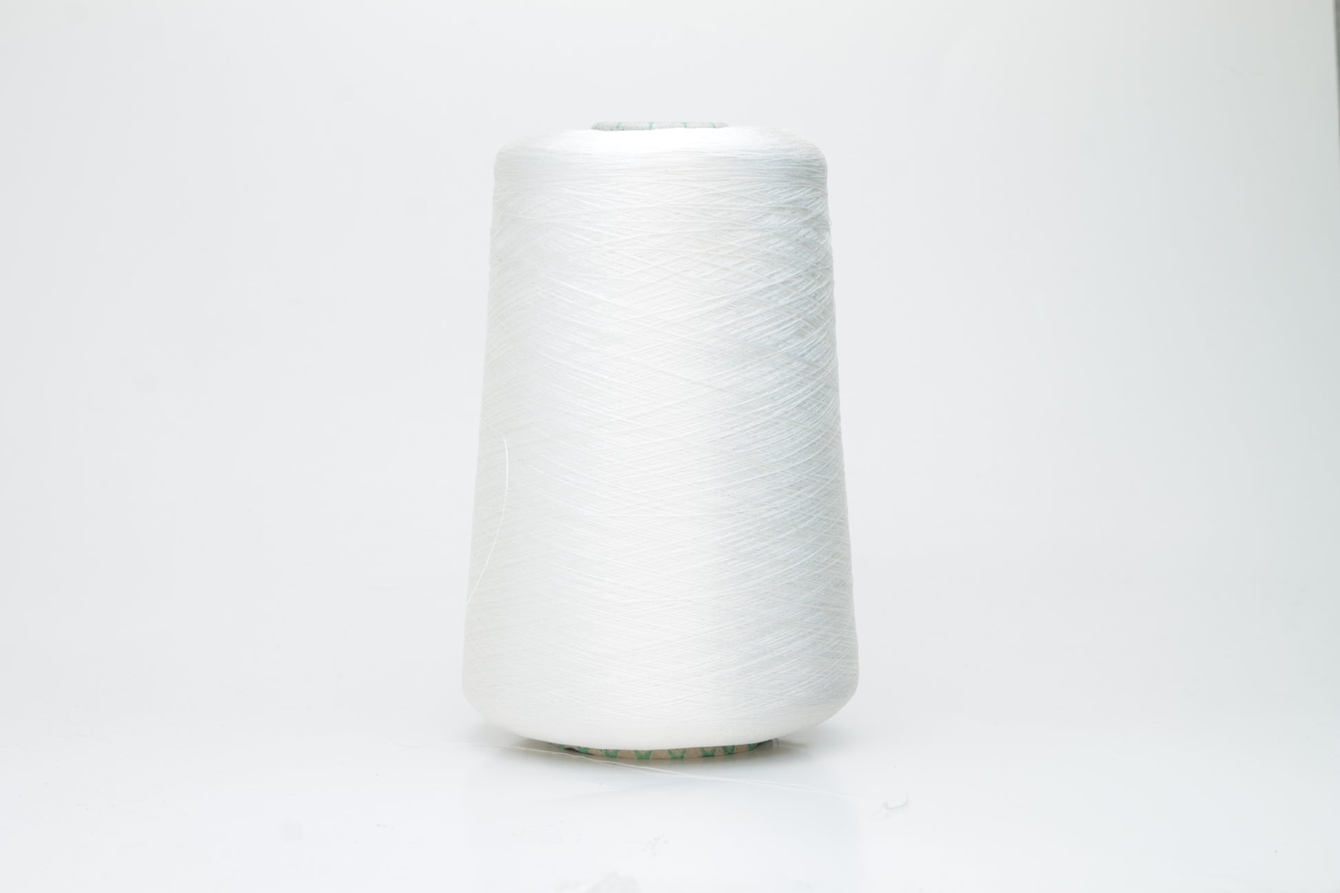Close-up of brilliant white 100% silk yarn, single-ply strand with a smooth, highly lustrous surface, softly draped. Shimmering.
